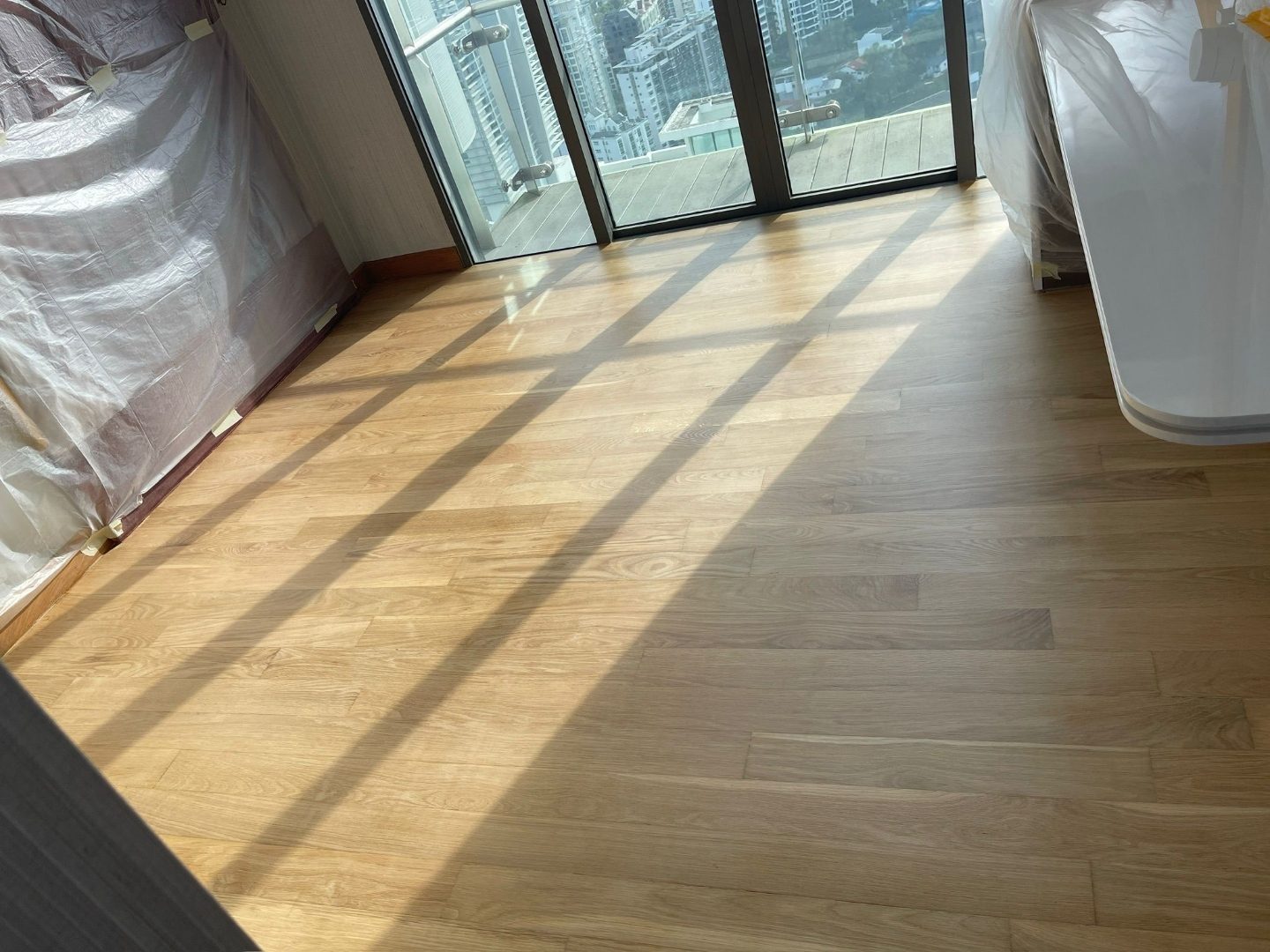 Master bedroom Maple wood flooring replacement at The Lumos condominium — before, in progress and finished views